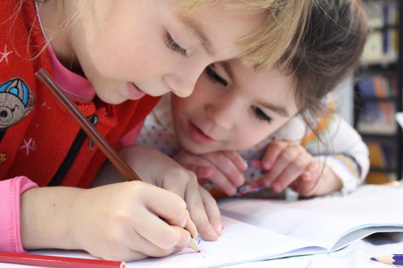 girls on desk looking at notebook