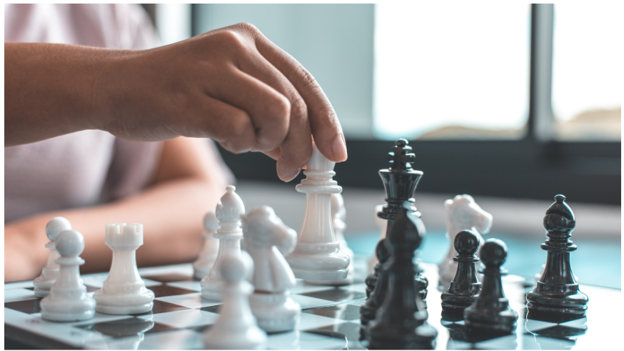 Someone moving a chess piece on a chess board.