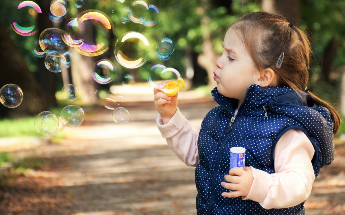 little girl blowing bubbles