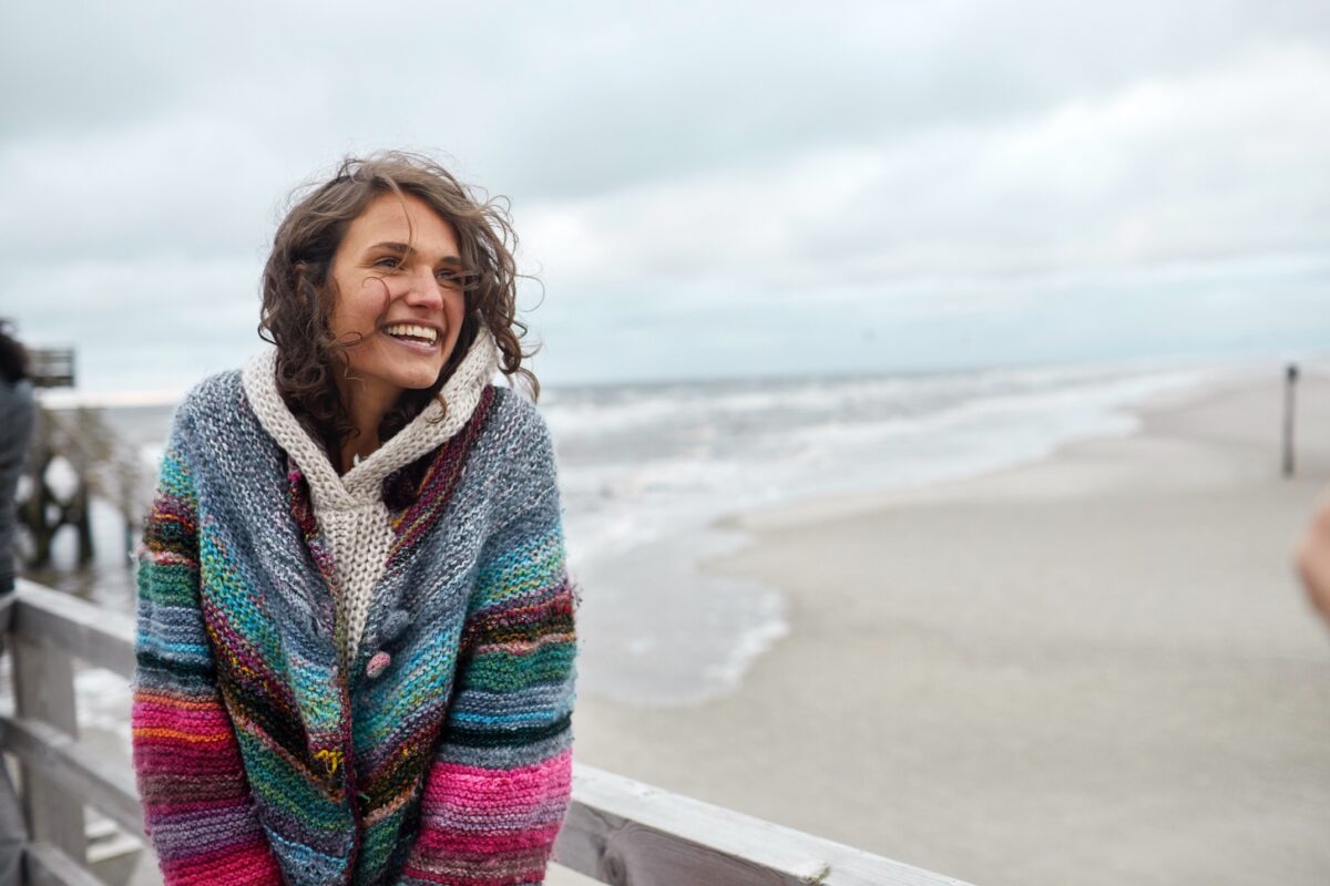 Happy girl looking out over a beach.